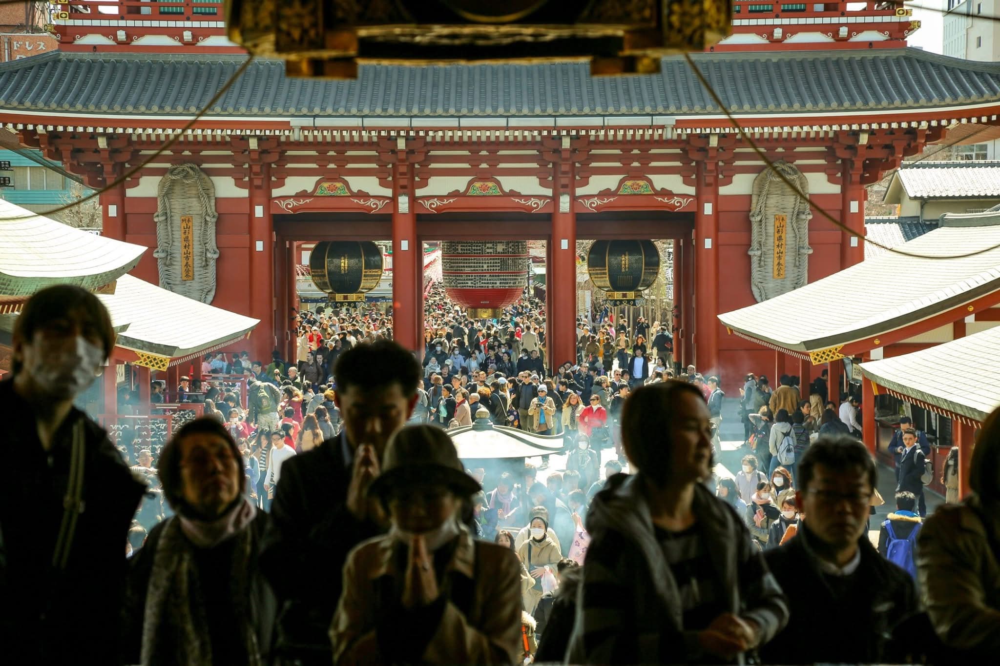 People gathered at a Japanese temple gate